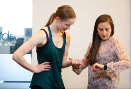 A picture of dancer having their pulse taken by a fitness professional